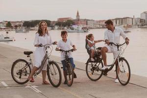 Die glückliche Familie genießt einen schönen Morgen am Meer, fährt zusammen Fahrrad und verbringt Zeit miteinander. das Konzept einer glücklichen Familie foto