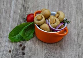 marinierte Champignons in einer Schüssel auf Holzhintergrund foto