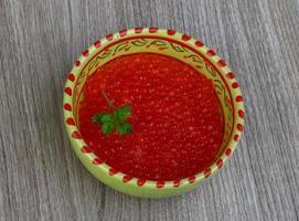 Roter Kaviar in einer Schüssel auf Holzhintergrund foto