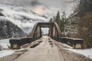 eine Betonbrücke in den schneebedeckten Bergen foto