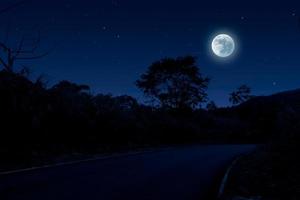 Dunkelblaue Nachtlandschaft mit leerer Straße foto