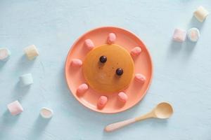 Leckerer gebratener Pfannkuchen mit schönem Gesicht isoliert, süßes Dessert foto