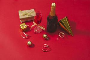champagner und weihnachtsschmuck auf rotem tischhintergrund foto