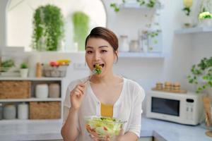 glückliche sexy Frau mit Salat auf weißem Hintergrund foto