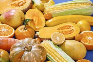 sammlung von frischem gelbem obst und gemüse auf blauem hintergrund foto