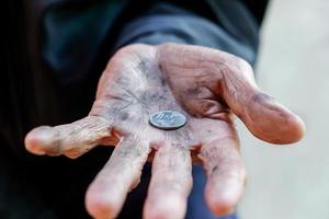 Hand alter Mann, der wegen des Hungers um Geld bettelt Vintage-Ton foto