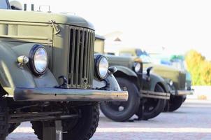 foto der kabinen von drei militärischen geländewagen aus der zeit der sowjetunion. Seitenansicht von Militärautos vom Vorderrad