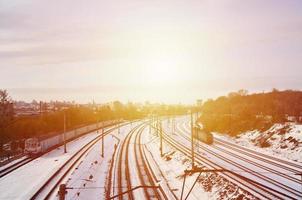 Winterlandschaft mit einem Eisenbahnzug vor einem bewölkten Himmelshintergrund foto