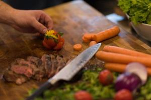 Nahaufnahme der Chefhände, die Rindersteak zubereiten foto