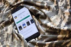ternopil, ukraine - 24. april 2022 luftangriffssirenen-app für handy auf smartphone-bildschirm auf der militärischen tarnung foto