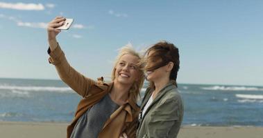 mädchen, die zeit haben und selfie am strand machen foto