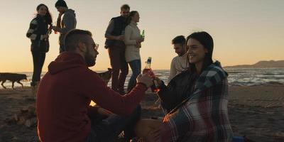 freunde, die sich am herbsttag am strand vergnügen foto