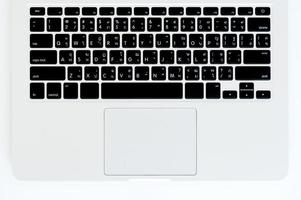 eine Laptop-Tastatur auf einem weißen Holztisch. Ansicht von oben foto