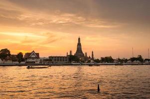 sonnenuntergang blick auf den wat arun tempel über den chao phraya fluss in bangkok, thailand. foto