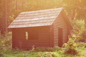 kleines Naturhaus, das aus Holz gebaut ist. Das Gebäude liegt im Wald foto