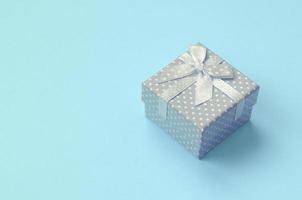 kleine blaue geschenkbox liegen auf texturhintergrund von pastellblauem modepapier foto