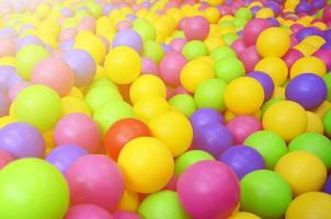 Viele bunte Plastikbälle in einem Bällebad für Kinder auf einem Spielplatz. Muster schließen foto