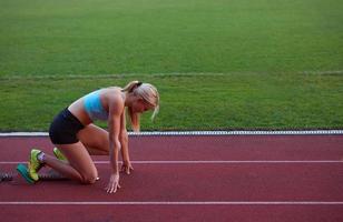 athletinnengruppe, die auf leichtathletik-rennstrecke läuft foto