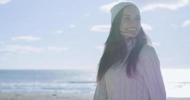 Mädchen in Herbstkleidung lächelnd am Strand foto