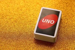 ternopil, ukraine - 15. mai 2022 viele bunte uno-spielkarten auf goldenem hintergrund. uno ist ein amerikanisches Kartenspiel vom Shedding-Typ, das mit einem speziell bedruckten Deck gespielt wird foto