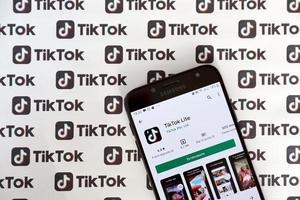 ternopil, ukraine - 2. mai 2022 tik-tok-smartphone-app auf dem bildschirm und viele tiktok-logos auf papier gedruckt. tiktok oder douyin ist ein berühmter chinesischer Kurzform-Video-Hosting-Service von bytedance foto