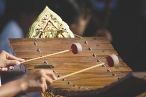 xylophon asiatische kultur klassisches musikinstrument gamelan, nahaufnahme übergibt musiker, der das thailändische hölzerne alt-xylophoninstrument schlägt. foto