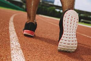 Nahaufnahme Schuh Fitness Menschen Läufer Athlet läuft auf der Straße bei Sonnenaufgang im öffentlichen Park. fitness- und trainings-wellness-konzept. Weicher Fokus. foto