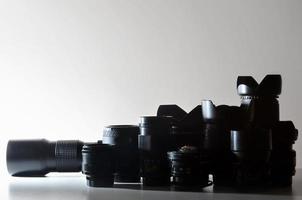 Viele verschiedene professionelle Objektive für Spiegelreflexkameras liegen auf einem farblosen Schreibtisch foto