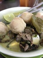 Soto ist ein typisch indonesisches Gericht mit Leber- und Fleischbällchen-Toppings sowie Limette als zusätzliches Aroma. drinnen gibt es zerkleinertes hähnchen mit leckerem warmem reis foto