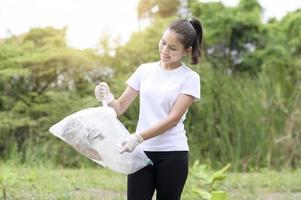 Frau sammelt Recycling-Müll auf dem Boden, ökologisch nachhaltiges Konzept. foto