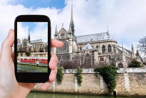 Fotografieren von Notre Dame Paris und Touristenboot foto