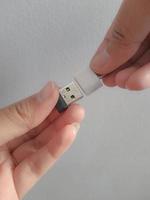 eine hand versucht, eine kleine kolbenscheibe in einen adapter usb typ c auf usb 3.0 typ-c adapter otg einzulegen foto