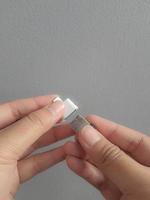 eine hand versucht, eine kleine kolbenscheibe in einen adapter usb typ c auf usb 3.0 typ-c adapter otg einzulegen foto