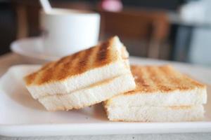 Draufsicht auf Erdnussbutter und ein Brot auf Teller auf schwarzem Hintergrund foto