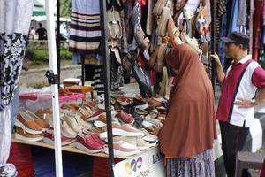 magelang, indonesien.05 10 2022.eine frau wählt schuhe an einem verkäuferstand bei einer autofreien tagesveranstaltung aus. foto