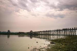 U-Bein-Brücke, die älteste und längste Teakholzbrücke der Welt, die den Taungthaman-See in der Nähe von Amarapura, Myanmar, überquert foto