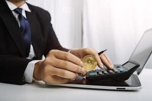 Unternehmerin, die einen Taschenrechner mit einem Stift in der Hand verwendet und die finanziellen Ausgaben im Home Office berechnet foto