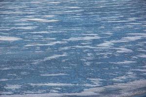 Winternaturhintergrund mit Eisblöcken auf gefrorenem Wasser im Frühjahr. abstrakter hintergrund von treibendem eis auf dem wasser foto