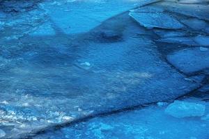 Winternaturhintergrund mit Eisblöcken auf gefrorenem Wasser im Frühjahr. abstrakter hintergrund von treibendem eis auf dem wasser foto