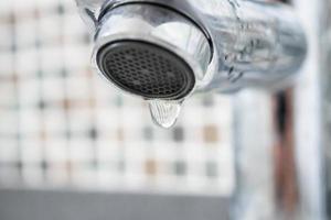 Wasserhahn mit Wassertropfen schließen foto