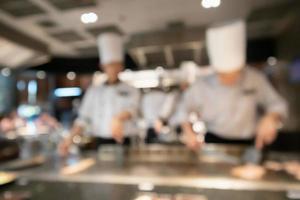 Küchenchef, der in der Restaurantküche kocht, verschwommener, defokussierter Hintergrund foto