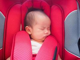 neugeborenes baby sitzt zur sicherheit im autositz foto
