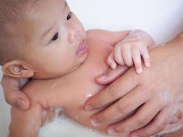 asiatisches neugeborenes mädchen, das mit mutter badet foto