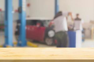 leere Holztischplatte mit Autoservice-Center Autowerkstatt unscharfer Hintergrund foto