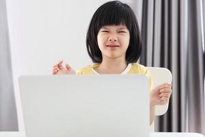 kleine asiatische studentin lernt online mit laptop-computer zu hause foto