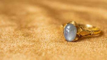 vintage goldschmuck blauer saphirring auf stoffstruktur foto