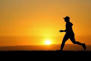 Menschen, die abends auf der Wiese joggen foto