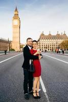 romantisches verliebtes paar stehen auf der westminster bridge mit big ben im hintergrund, reisen in london, großbritannien, posieren vor der kamera, umarmen sich, haben glückliche ausdrücke. Menschen, Reisekonzept foto