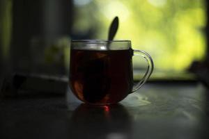 Tee im Glas. Tee am Morgen. transparente Tasse auf dem Tisch. Frühstück im Morgengrauen. foto