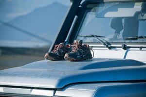 Trekkingschuhe trocknen auf einer schmutzigen 4WD-Motorhaube foto